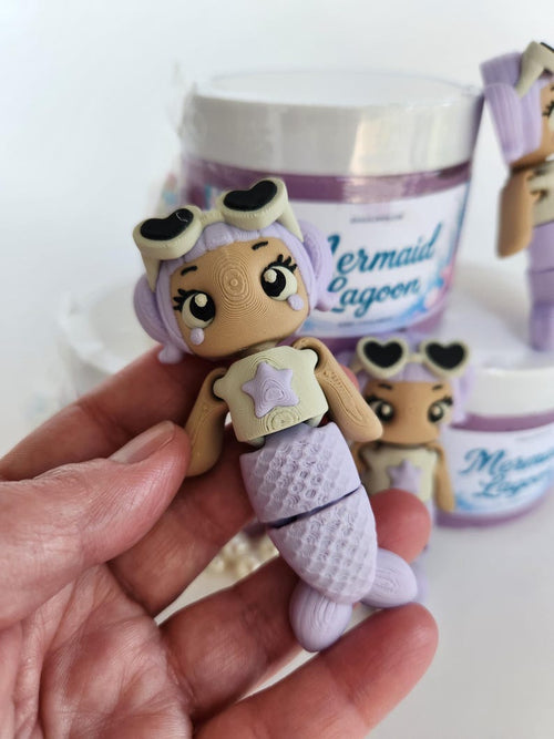 3D printed purple mermaid figurine with heart sunglasses next to Mermaid Lagoon slime jar